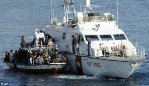 An Italian Coast Guard vessel rescuing a boat full of Tunisian migrants off the coast of Lampedusa in 2011. A state of emergency was declared in Italy after 4,000 immigrants arrived in just 4 days following the fall of Tunisia's ruler.