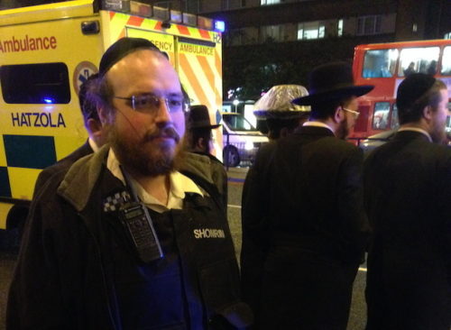 Michael Scher standing in front of a Hatzola ambulance at the scene of a hit and run in Stamford Hill.