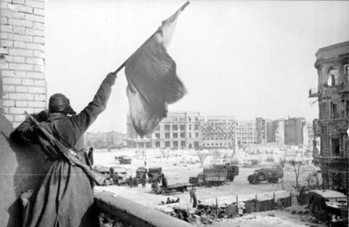 Soviet soldier waving the Red banner over the central plaza of Stalingrad