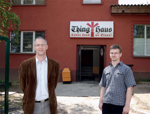 Stefan Köster, head of NPD in Mecklenburg-Vorpommern, and David Petereit, editor of MUPInfo, in front of Thinghaus in Grevesmühlen. The motto reads "Better dead than a slave."