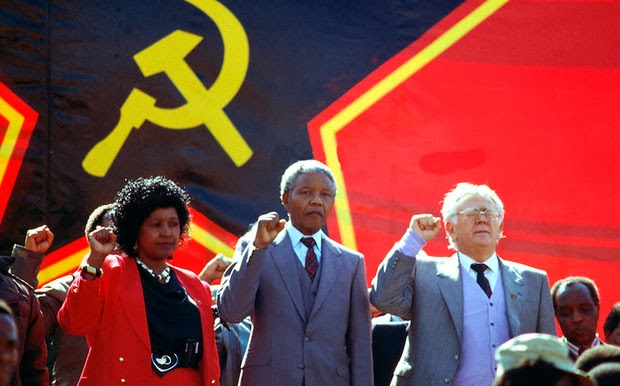 https://nationalvanguard.org/wp-content/uploads/2015/08/Winnie_Mandela_Nelson_Mandela_Yossel_Joe_Slovo_hammer_and_sickle_red_star_flag_banner.jpg