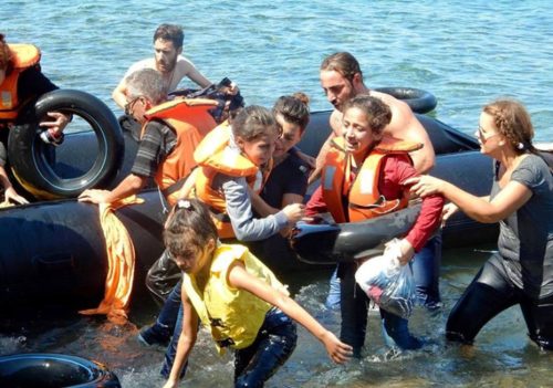 Israeli Jews working for IsraAID, including global programs manager, Naama Gorodischer, center, helping nonwhite invaders reach the shore after their boat overturned off the Greek coast, September 13, 2015.