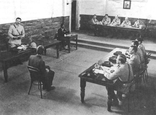 Courtroom scene from the 1980 Australian film "Breaker Morant," which highlighted the British policy of shooting Boer prisoners during the war in South Africa. The film dramatized the case of several Australians serving with the Bush Veldt Carbineers, a special "anti-commando" unit, who were tried and executed in February 1902 for having shot twelve Boer prisoners. In the award-winning film, Edward Woodward played the role of Lt. "Breaker" Morant.
