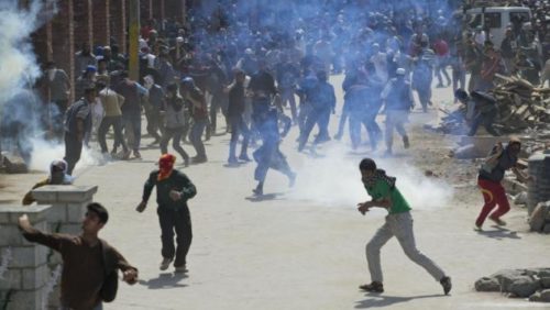Kashmiri protesters throw stones and bricks at Indian policemen during a protest in Srinagar, Indian controlled Kashmir, Friday, April 17, 2015. Police fired tear gas and rubber bullets Friday to disperse hundreds of demonstrators in Indian-controlled Kashmir who hurled rocks and chanted anti-Indian and pro-Pakistan slogans to protest the killing of a militant commander's brother. The Indian army said the man was killed in a gunbattle along with a militant on Monday, while his relatives and local residents said he was tortured to death. (AP Photo/Dar Yasin)