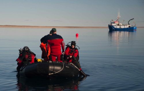 Parks Canada's underwater archeology team prepares to enter the water on a dive to the wreckage of HMS Erebus in 2015, while being supported by the Arctic Research Foundation's vessel the Martin Bergmann. The same vessel located HMS Terror after detouring to Terror Bay on the advice of an Inuit crew member.
